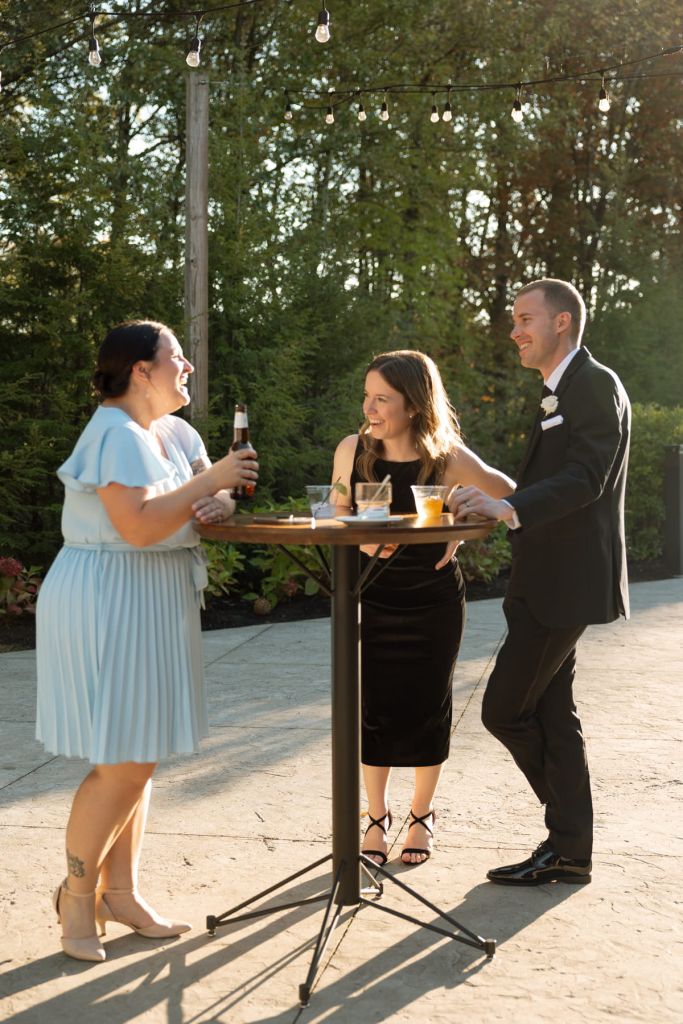 Wedding guests and groom chatting during cocktail hour