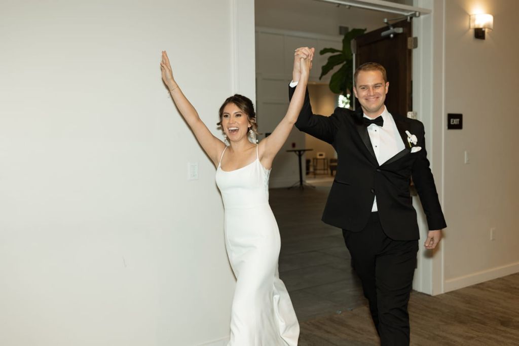 Bride and groom reception entrance, hands in the air