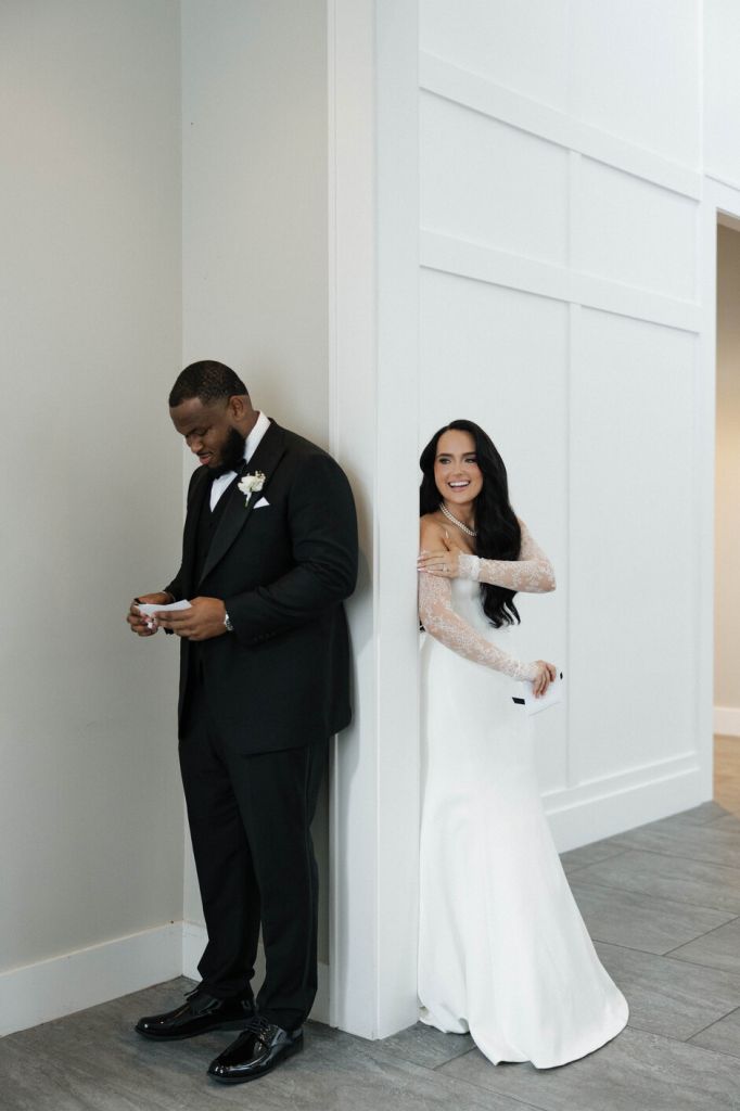 Bride and groom first look around corner surprise