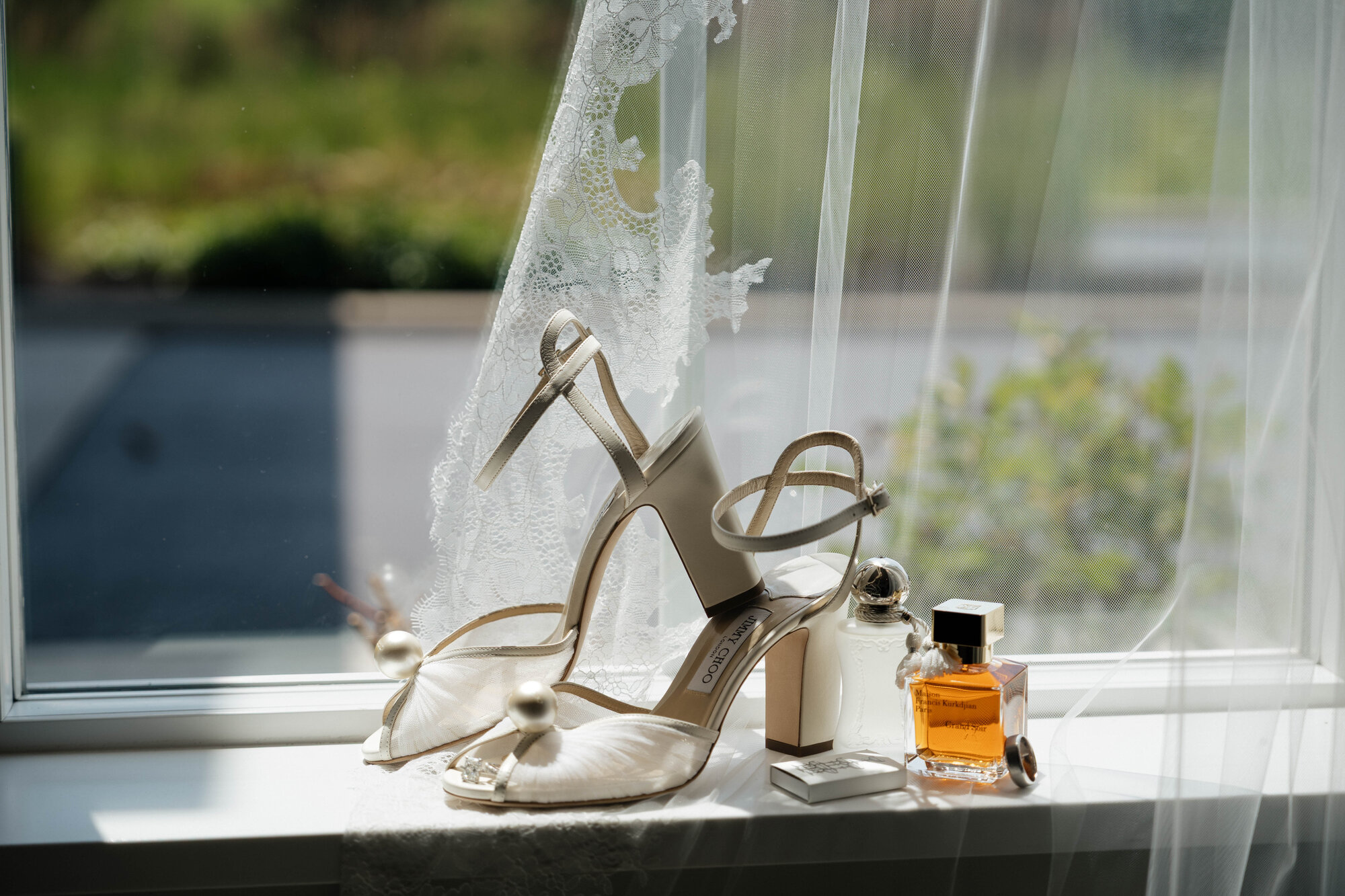 Bride's shoes and perfume on window sill